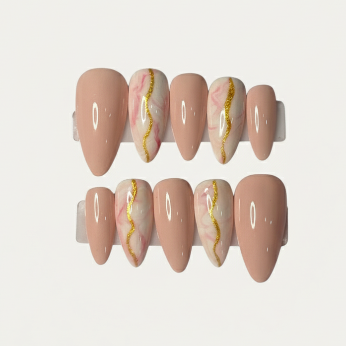 Set of pink nail caps with gold and white marbling on a light gray background