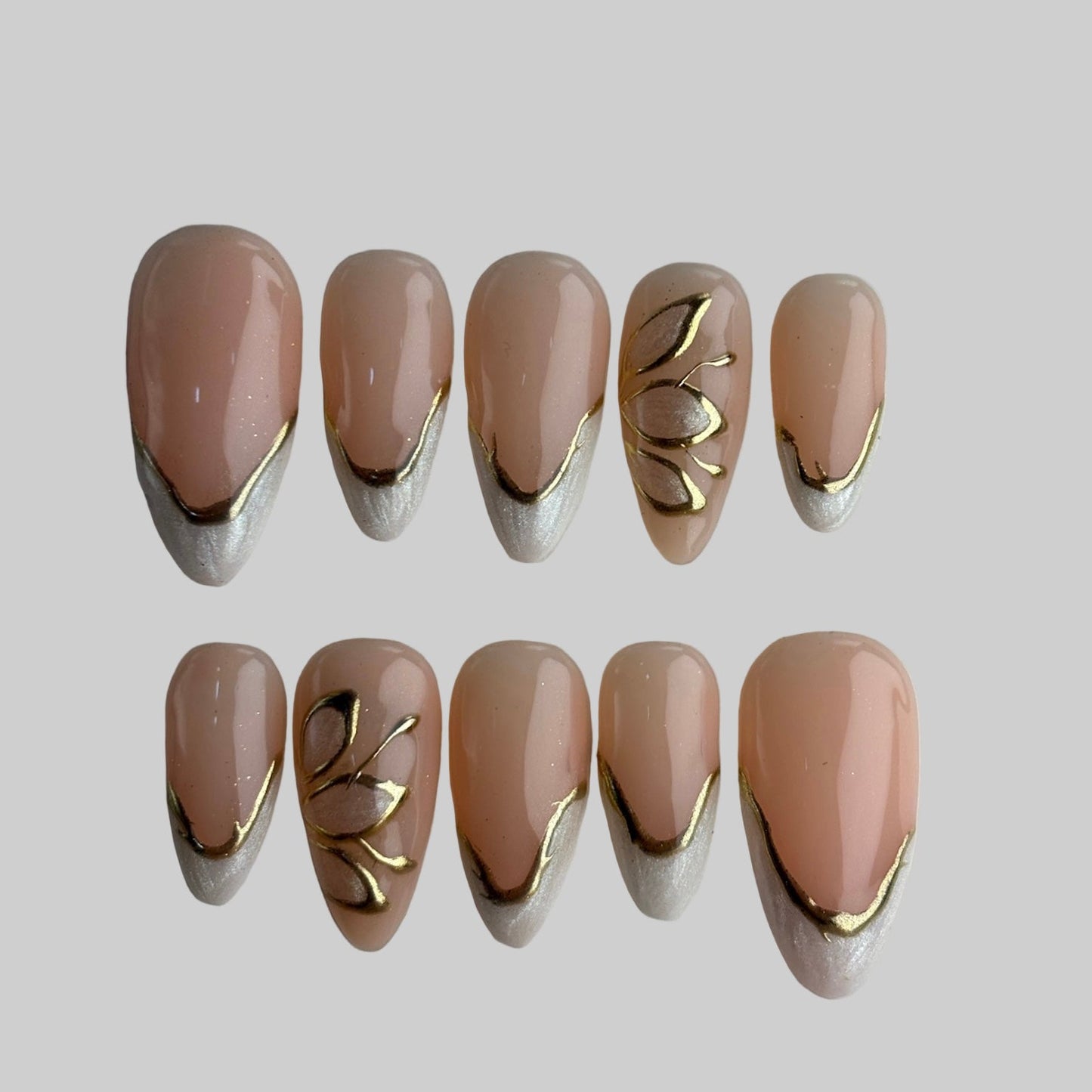 Set of beige nail art designs with gold accents on a light gray background
