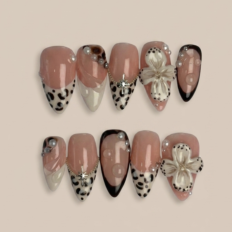 Set of decorative nails with animal print and bow designs on a beige background